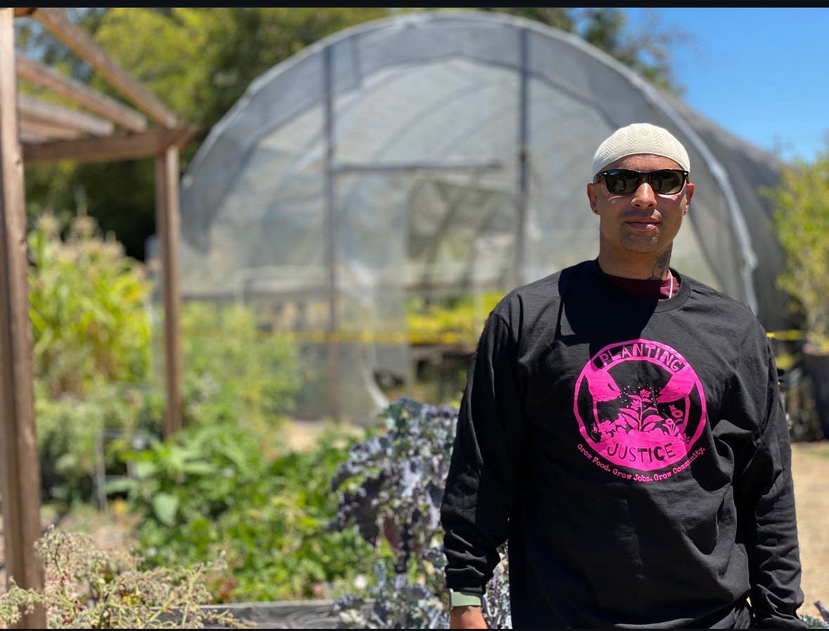 photo of Rasheed Patch standing in front of a greenhouse